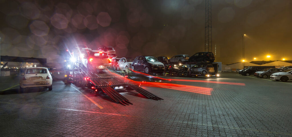 Cars being driven aboard auto transport - en route to dealerships. The picture is taken in the evening, showcasing SAL's 24/7 opening hours.